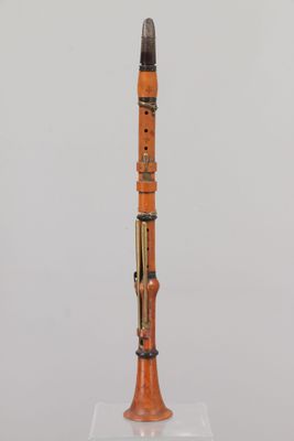 an orange and black instrument sitting on top of a glass stand