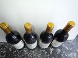 four bottles of wine are lined up in a row on a counter