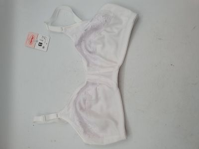 une bralette blanche posée sur une table blanche, à côté d'une étiquette