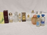 many bottles of perfume sitting on a white surface