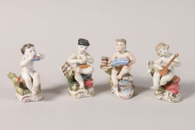 quatre figurines représentant des enfants jouant d'instruments de musique sur un fond blanc