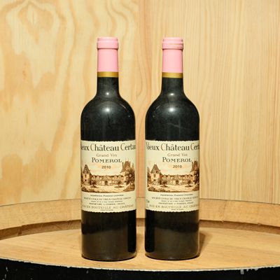 two bottles of wine sitting on top of a barrel
