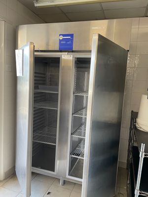 un réfrigérateur ouvert dans une cuisine au sol carrelé