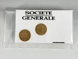 deux pièces d'or dans un sachet en plastique transparent posé sur une surface blanche