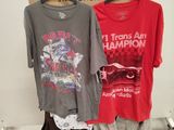 two shirts that are on a rack in a room