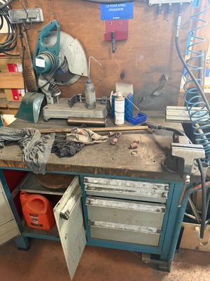 une photo d'un établi dans un garage avec des outils dessus