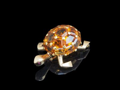 une photo d'une bague sertie d'un diamant jaune posée sur une surface noire