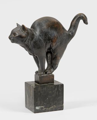 une statue en bronze représentant un chat debout sur un bloc de marbre