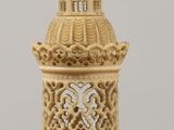 a small gold clock tower on a wooden table