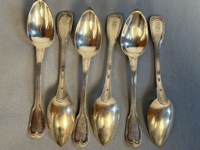 six spoons are lined up in a row on a table