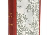 un vieux livre à la couverture rouge posé sur une surface blanche