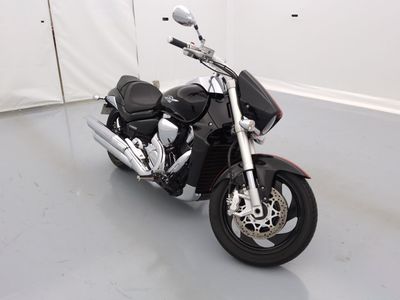 une moto noire garée dans une pièce aux murs blancs