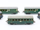 several toy trains are lined up in a row on a white surface