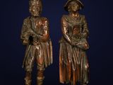 a pair of bronze figures of a man and a woman standing next to each other