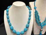 a close up of a necklace and a necklace on a mannequin