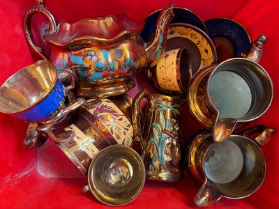 a lot of antique silver and gold items in a red bag