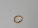 gros plan d'une bague en or sur une surface blanche