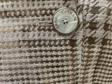a close up of a button on a shirt with a checkered pattern
