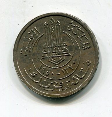 La pièce repose sur une surface blanche sur laquelle figure une inscription en arabe.
