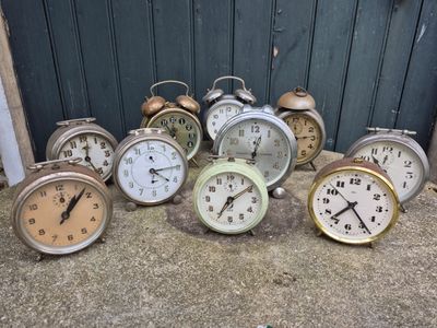 a lot of clocks sitting on the ground in front of a door