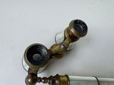 an old brass faucet and a glass of wine on a table