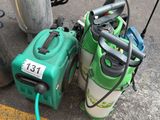 two green and white sprayers on the ground next to a pole