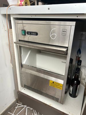 une photo d'une cuisine avec un réfrigérateur et des bouteilles de vin