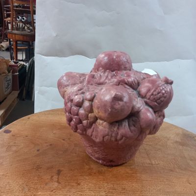 a pink vase sitting on top of a wooden table