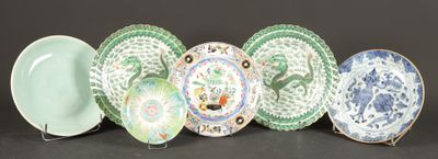 five plates with different designs are lined up on a black surface