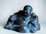 buddha figurine sitting on a white surface with a white background