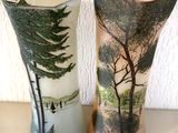 deux vases posés sur une table, sur lesquels sont peints des arbres