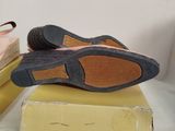 pair of women ' s shoes sitting on top of a box on a bed