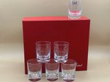 four shot glasses and a bottle of water sit in front of a red box