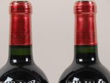 two bottles of wine sitting next to each other on a table