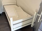 a small white bed in the corner of a room