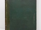 an old green book sitting on top of a white table