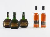 trois bouteilles d'alcool sont alignées sur une surface blanche