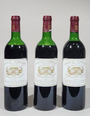 three bottles of wine are lined up on a white surface