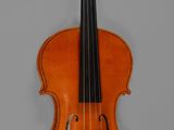an old violin sitting on top of a table next to a wall