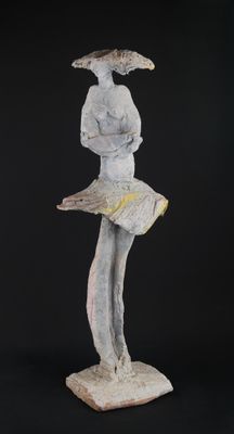 statue of a woman reading a book with a hat on her head