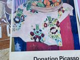 tableau représentant une corbeille de fruits posée sur une table, à côté d'une pile de papiers