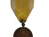 une vieille médaille ornée d'un ruban doré sur fond blanc