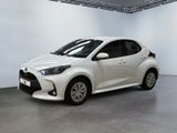 La Toyota Yaris est garée dans une pièce blanche, devant un mur blanc.