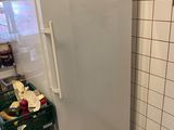 un réfrigérateur blanc dans une cuisine aux murs carrelés