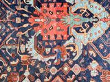 an antique persian rug with blue and red colors