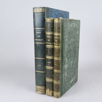 deux vieux livres posés l'un sur l'autre sur une surface blanche