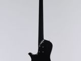 an electric guitar hanging from a string on a white wall