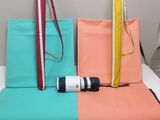 un lit recouvert d'un couvre-lit bleu, orange et rose, sur lequel est posé un sac