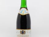 a bottle of red wine sitting on top of a white table