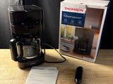 une cafetière posée sur une table à côté d'une boîte